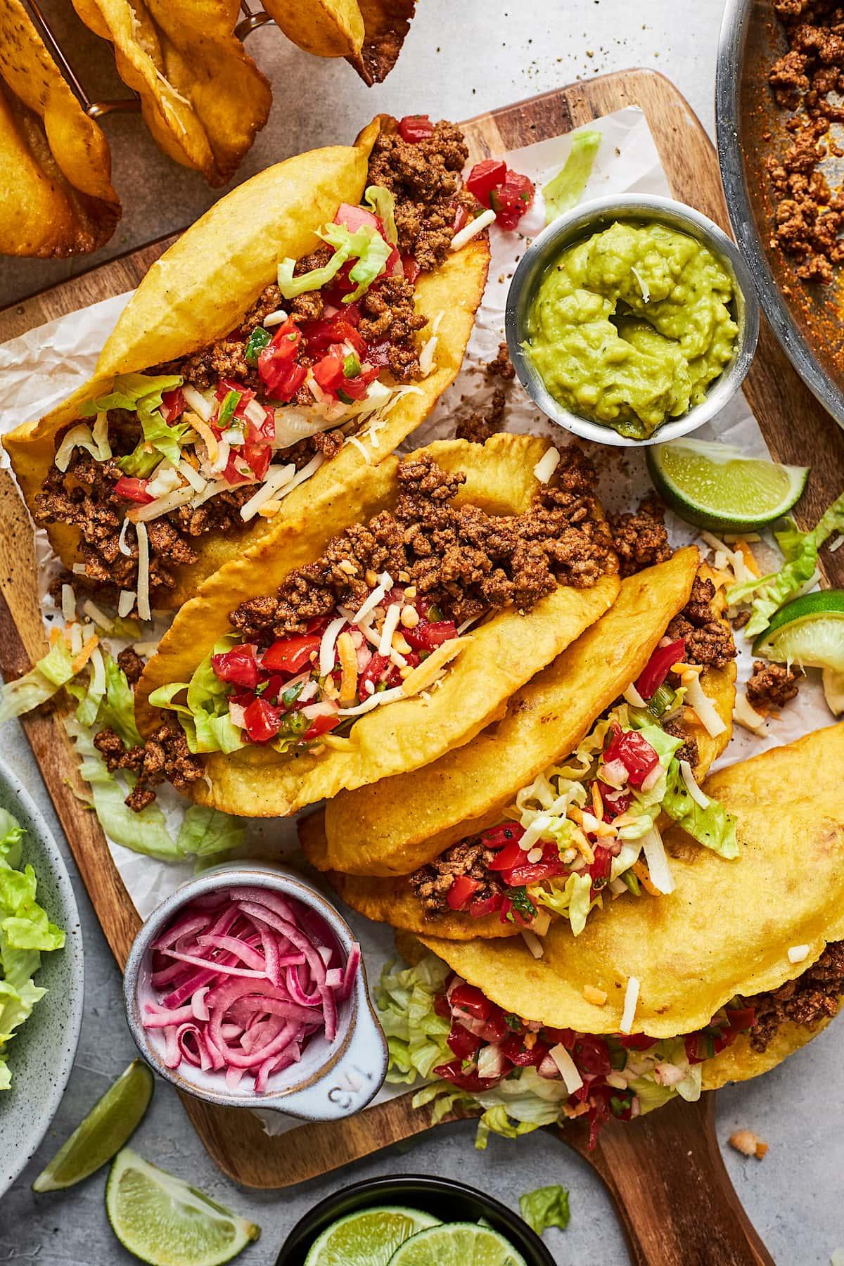 assembled inside-out ground beef tacos with pretzel buns and toppings
