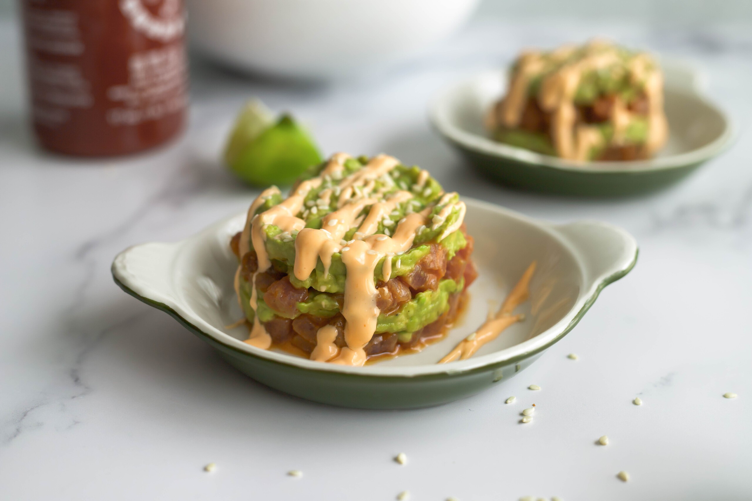 spicy tuna and avocado salad served on a plate with crackers