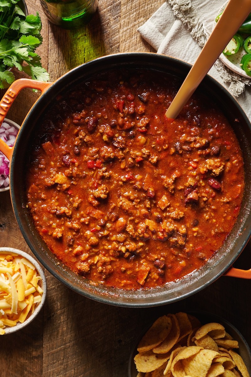 a pot of steaming homemade chili with toppings