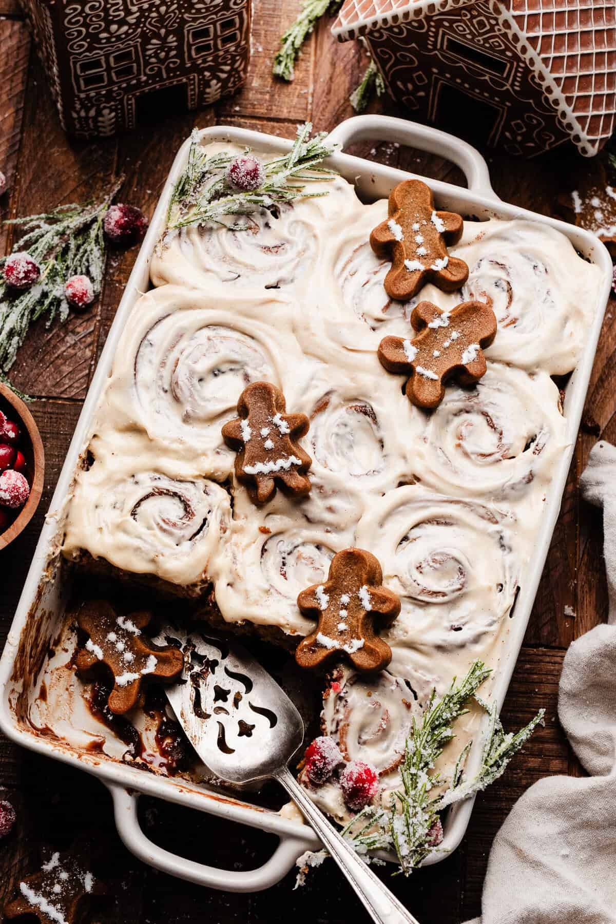 beautifully iced cinnamon roll loaf on a rustic wooden board, decorated for holidays