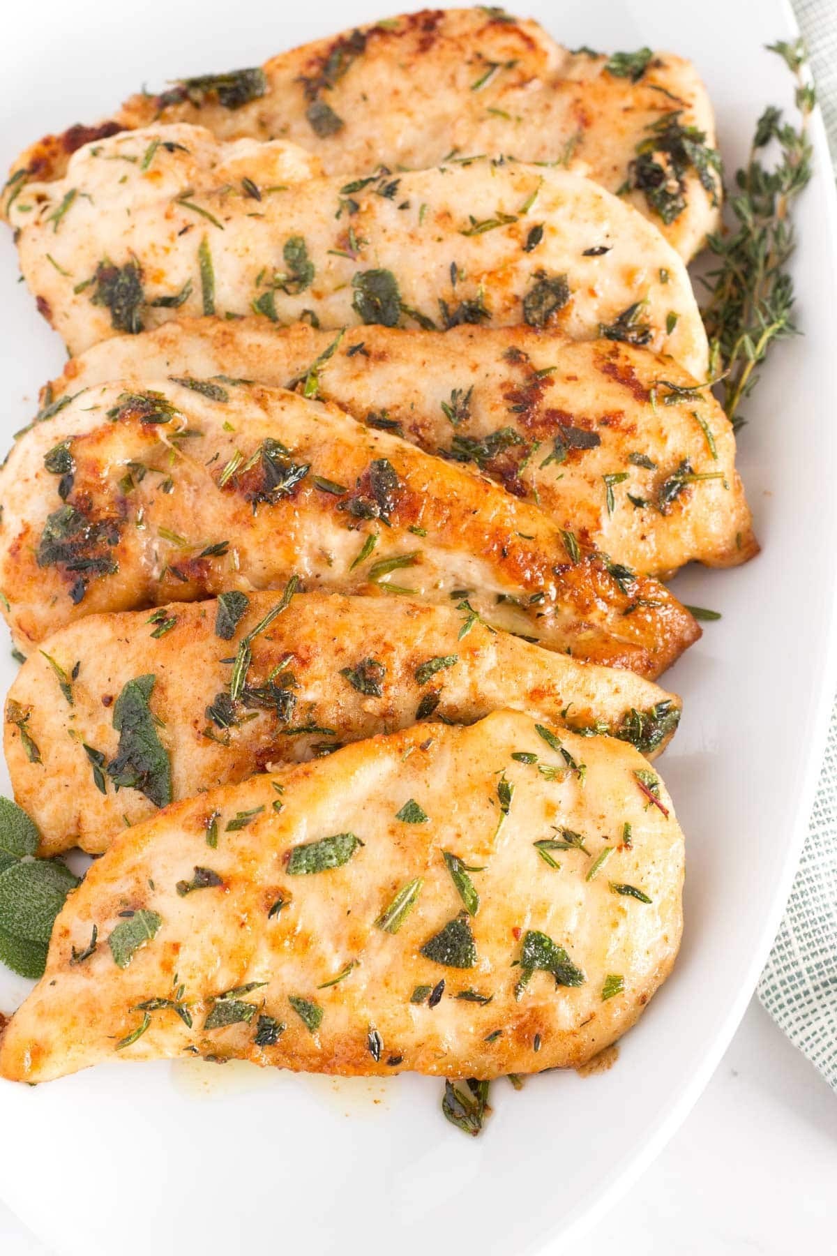 golden brown butter-seared chicken with herbs on a platter, festive holiday table