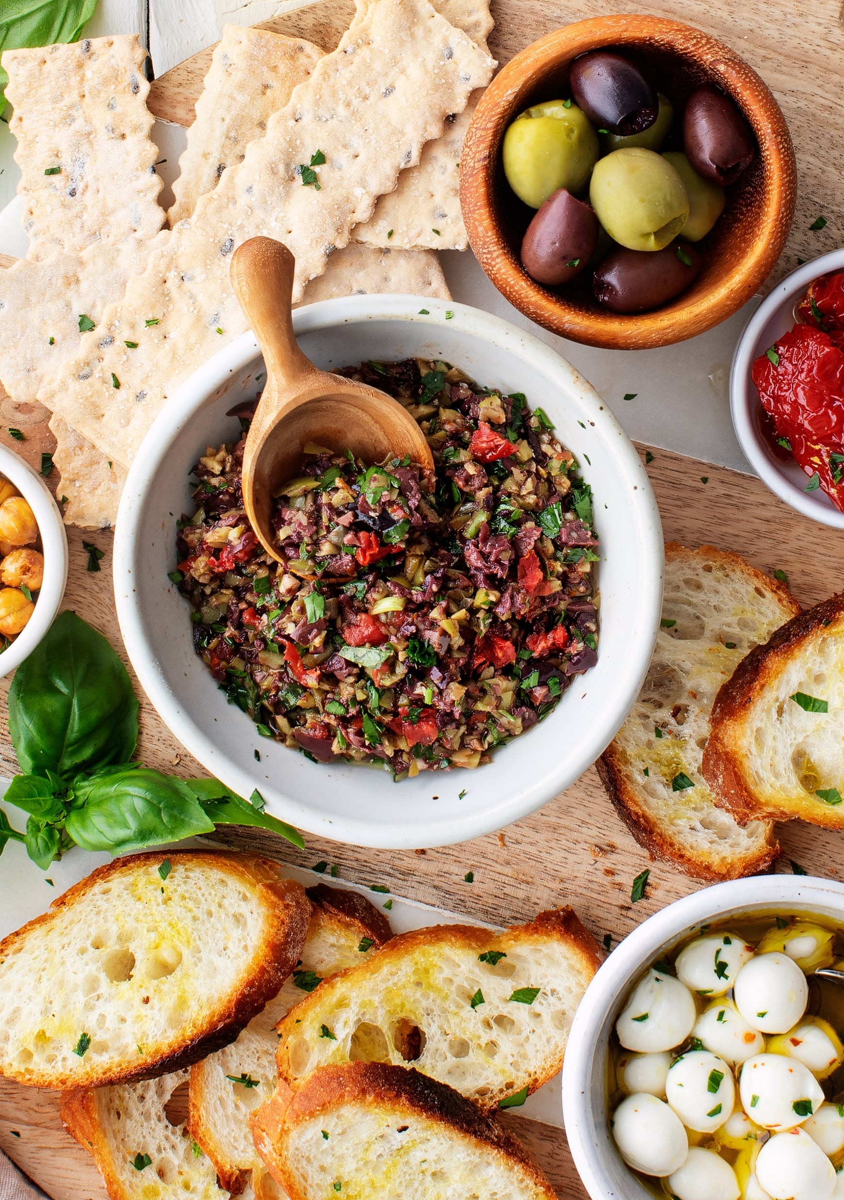 Olive tapenade served on crostini with a side of fresh vegetables
