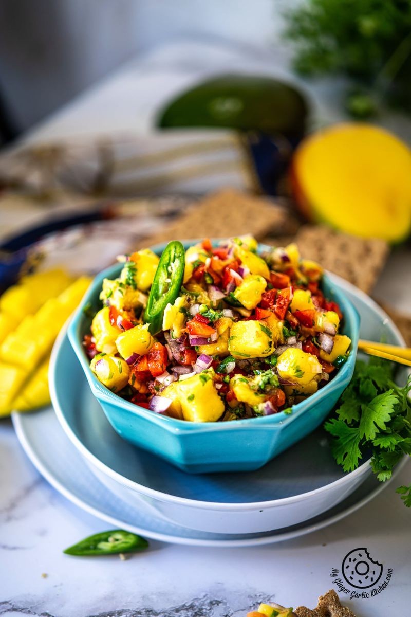 bright and colorful pickled ginger mango salsa in a bowl, garnished with cilantro