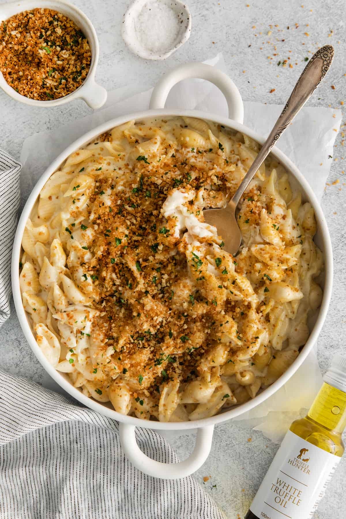 Gourmet truffle mac and cheese with creamy sauce, garnished with fresh herbs, close-up, rustic setting