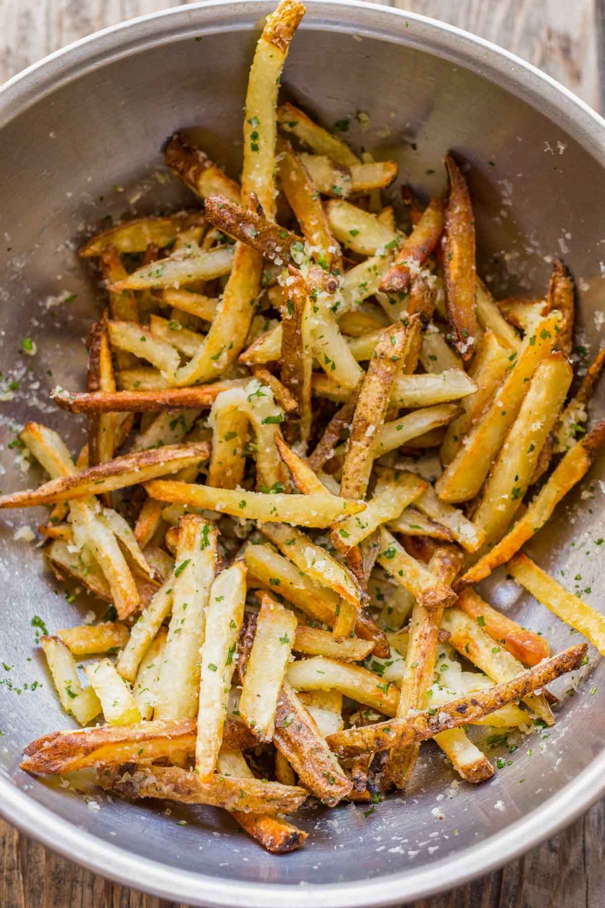 close up of truffle parmesan carrot fries on a plate, drizzled with oil
