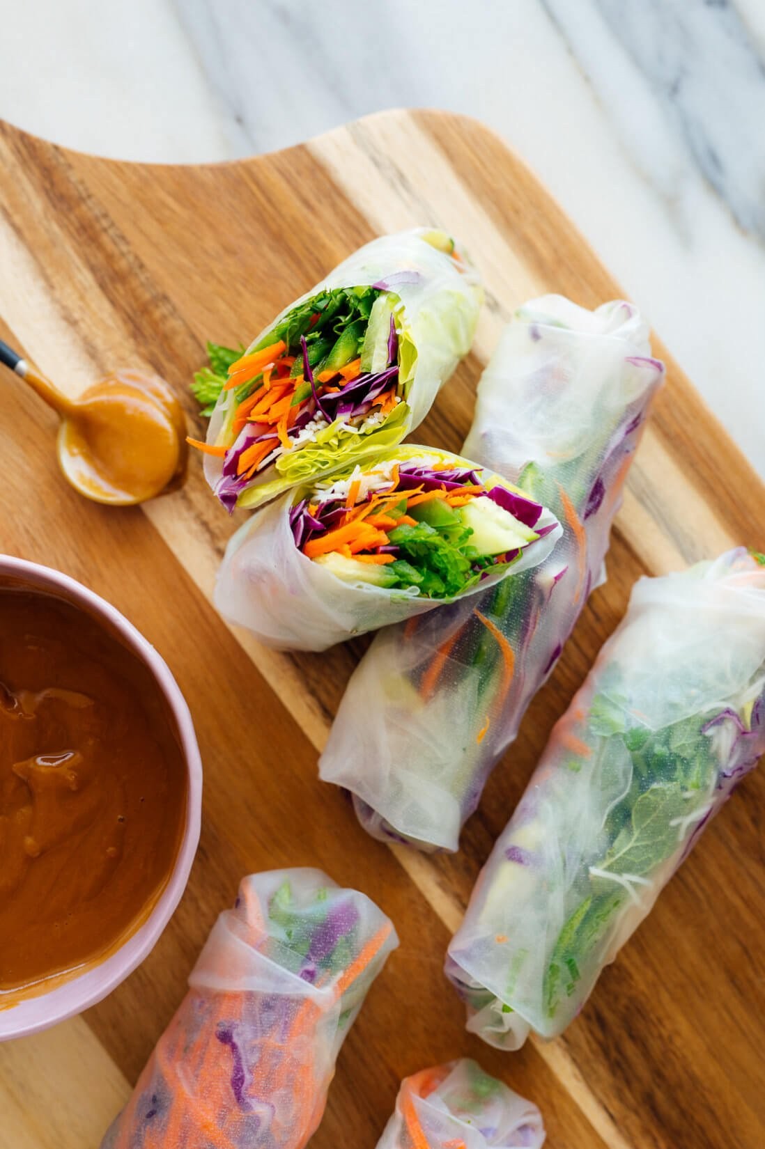 close-up of colorful asian slaw spring rolls with peanut sauce