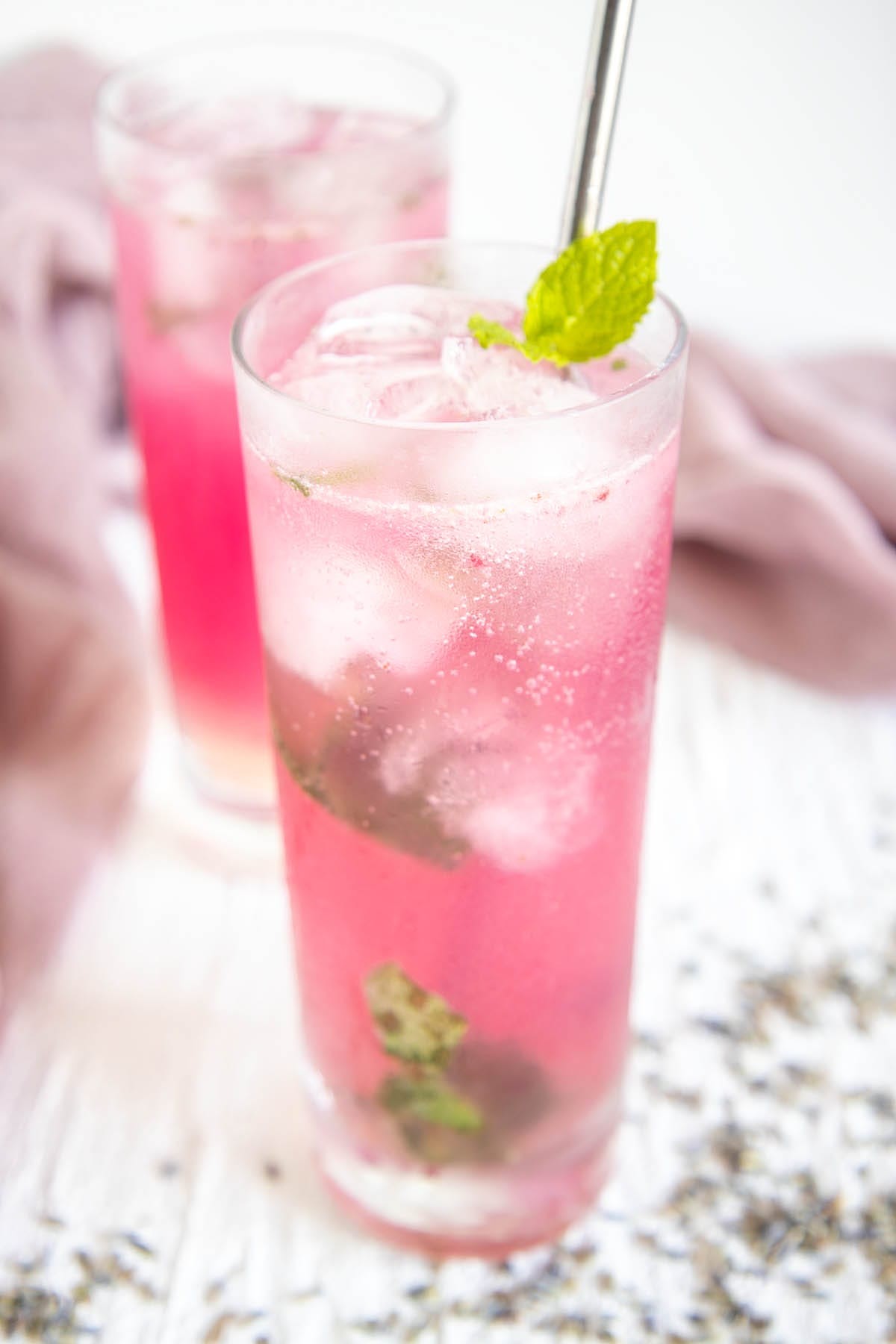 lavender lemon virgin mojito in a clear glass with ice and mint garnish
