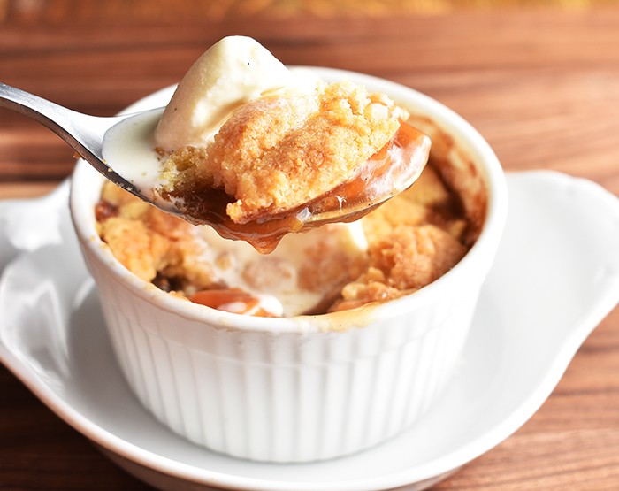 golden peach cobbler with a scoop of vanilla ice cream