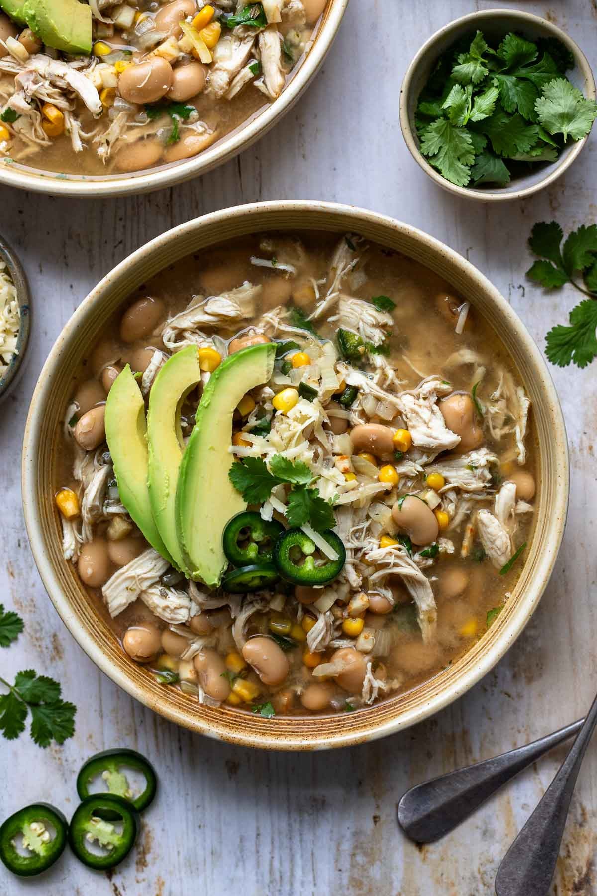 white chicken chili bowl with roasted corn garnish and warm lighting