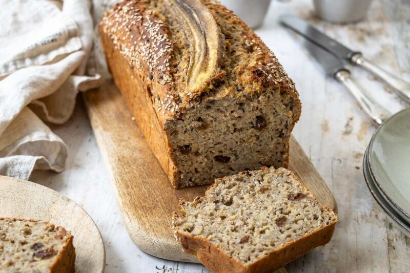 Warm banana spice sugar bread loaf on a cooling rack, rustic kitchen setting
