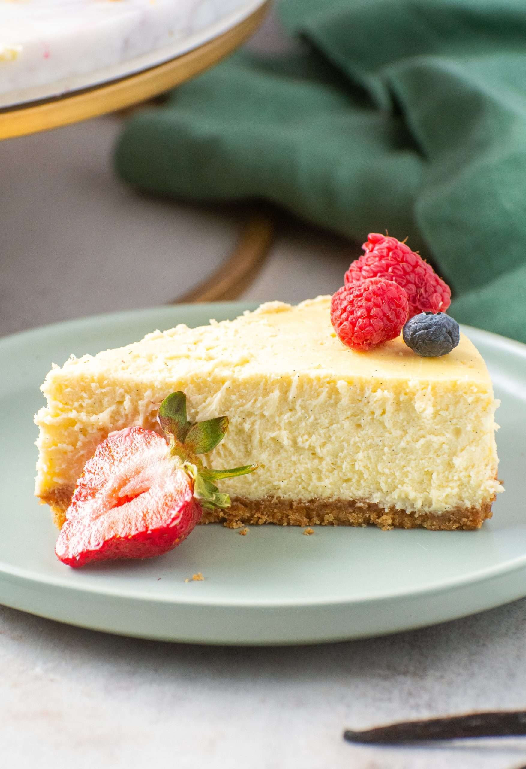 slice of vanilla bean cheesecake with a silky texture on a plate, close up, warm lighting