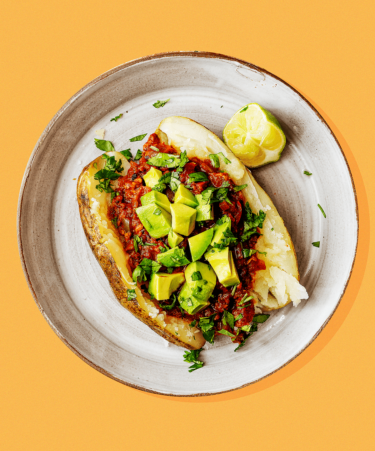 vegan chili baked potato topped with avocado