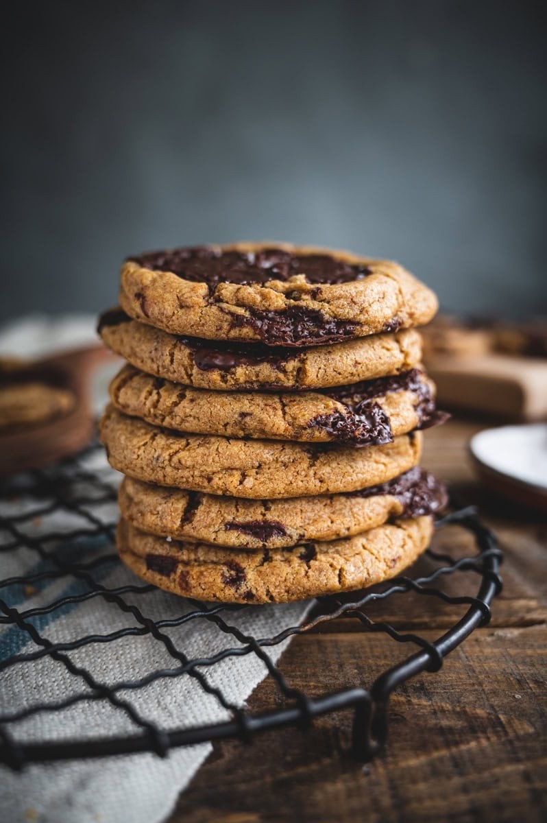 stack of perfectly soft chocolate chip cookies on a cooling rack, golden brown, melted chocolate chips visible