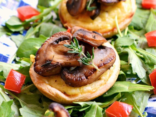 close-up golden brown mini cheese tarts with fresh herbs, rustic background