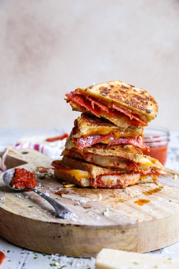 golden crispy pepperoni pizza grilled cheese sandwich, oozing mozzarella, tomato dip, close up