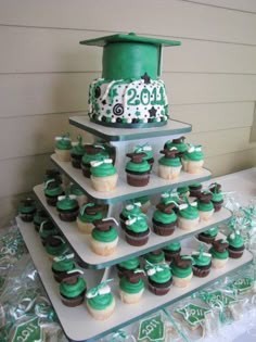 a batch of vibrant green cupcakes decorated with graduation caps and books