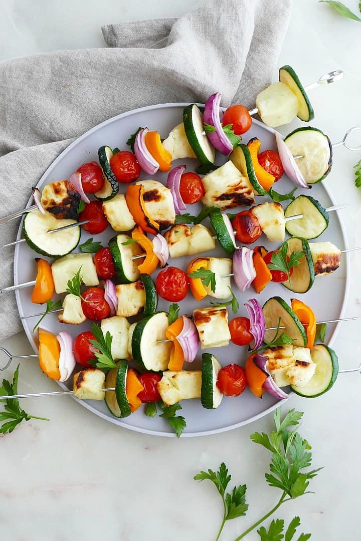 close-up of grilled halloumi and vegetable skewers served over a bed of fresh salad greens