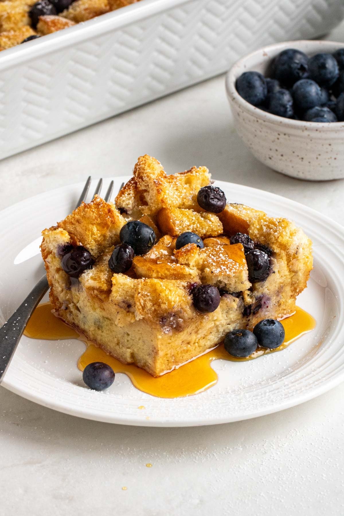 Blueberry French Toast Bake with powdered sugar and fresh blueberries, rustic setting