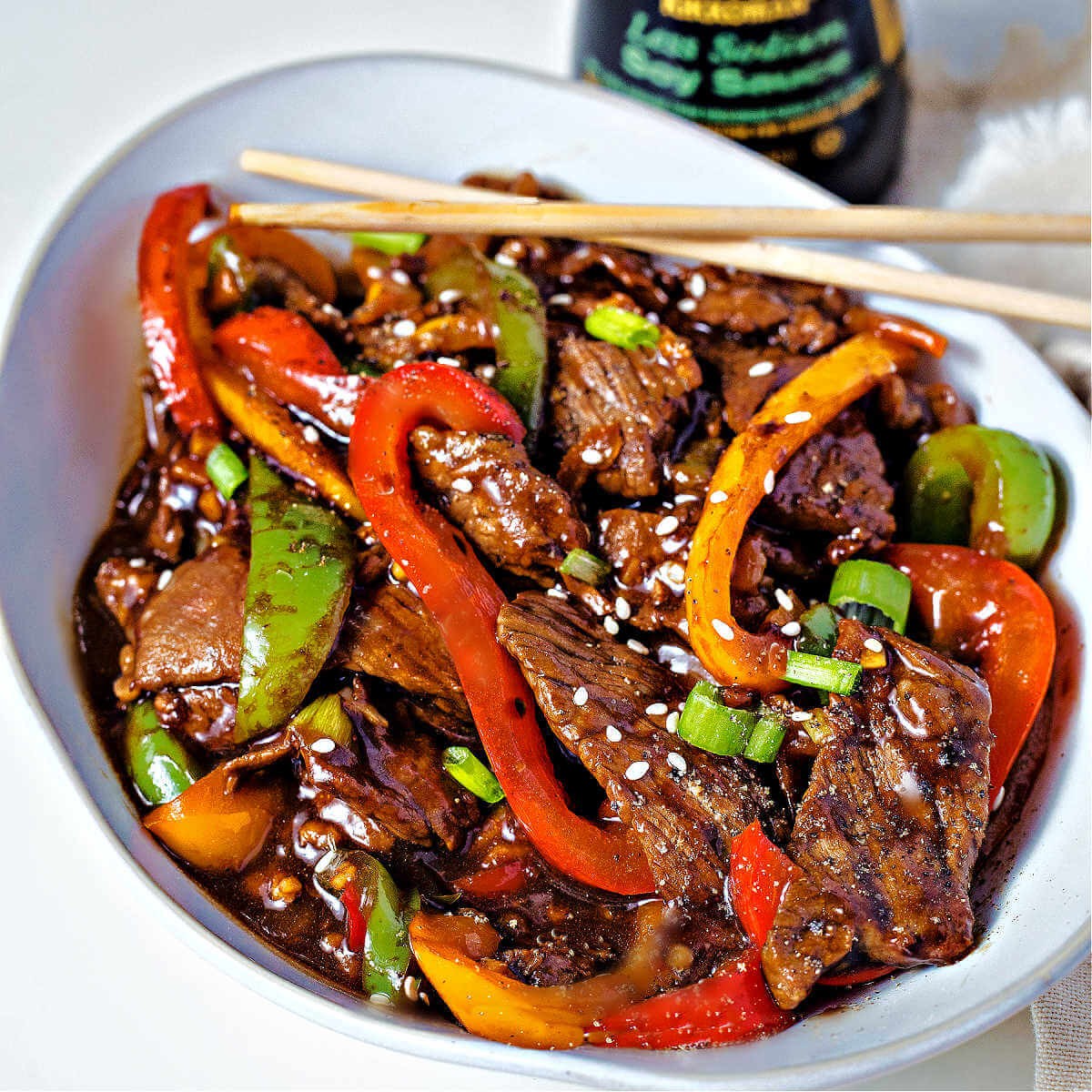 beef and bell pepper stir-fry being cooked in a wok