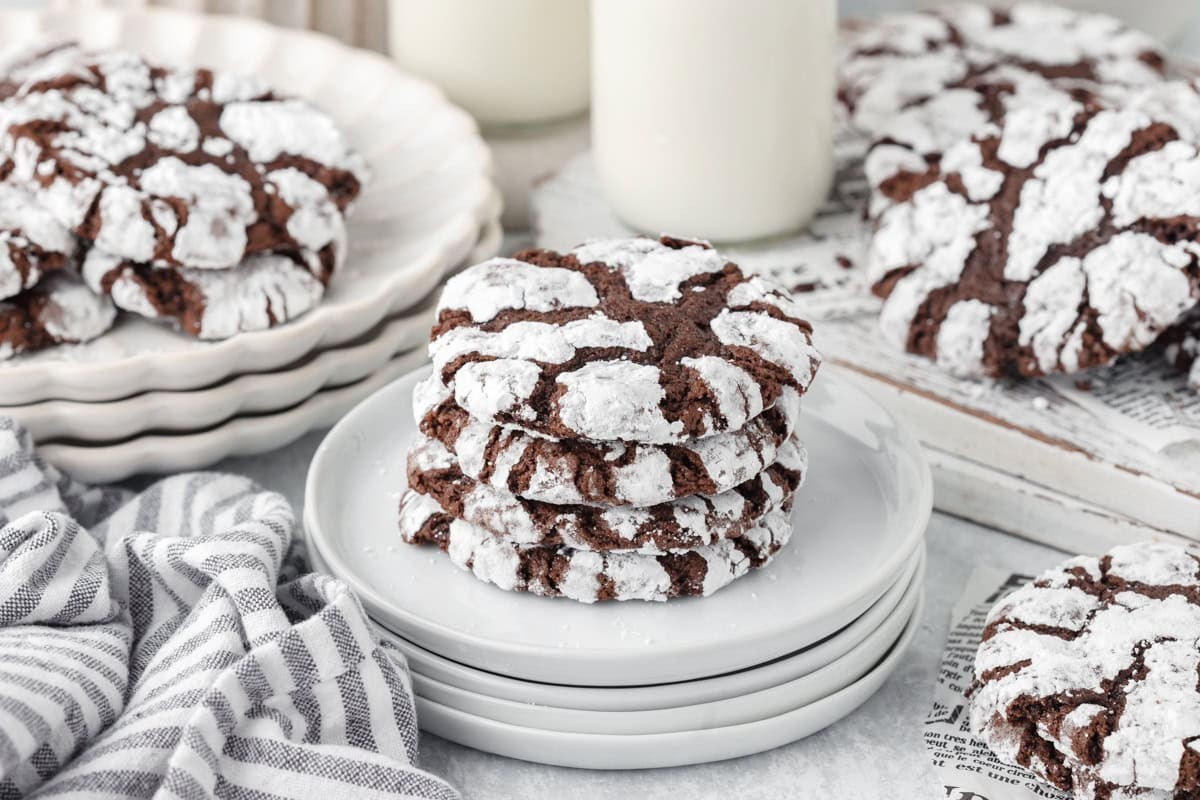 Plate of fresh baked chocolate crinkle Christmas cookies dusted with powdered sugar, festive background