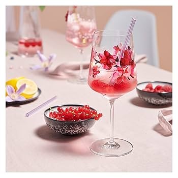 person preparing Hugo Rosato cocktail with rose petals and crystal glass