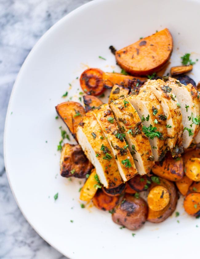 vibrant herb-roasted chicken and vegetables in a healthy dinner bowl, overhead shot