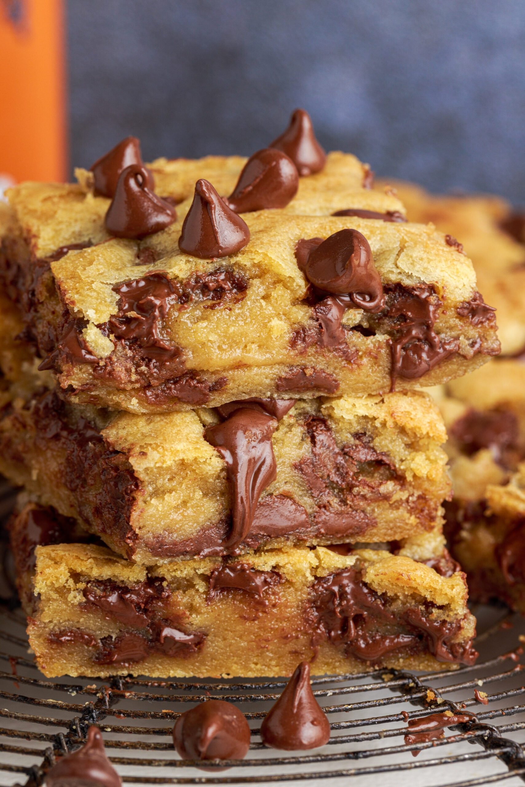 freshly baked chocolate chunk cookie bars cooling on a wire rack, with some cut to show gooey interior