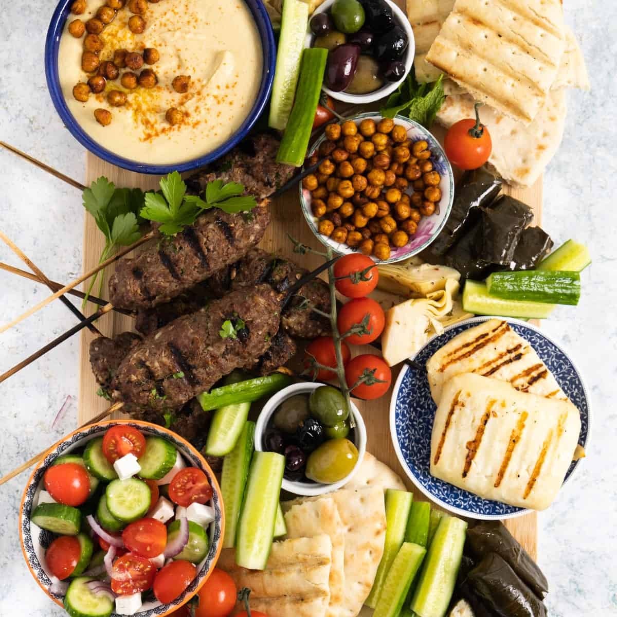 overhead shot of a colorful grilled Mediterranean platter with hummus and pita bread