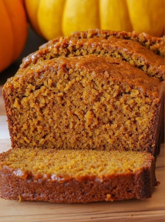 slices of moist pumpkin bread on a wooden cutting board