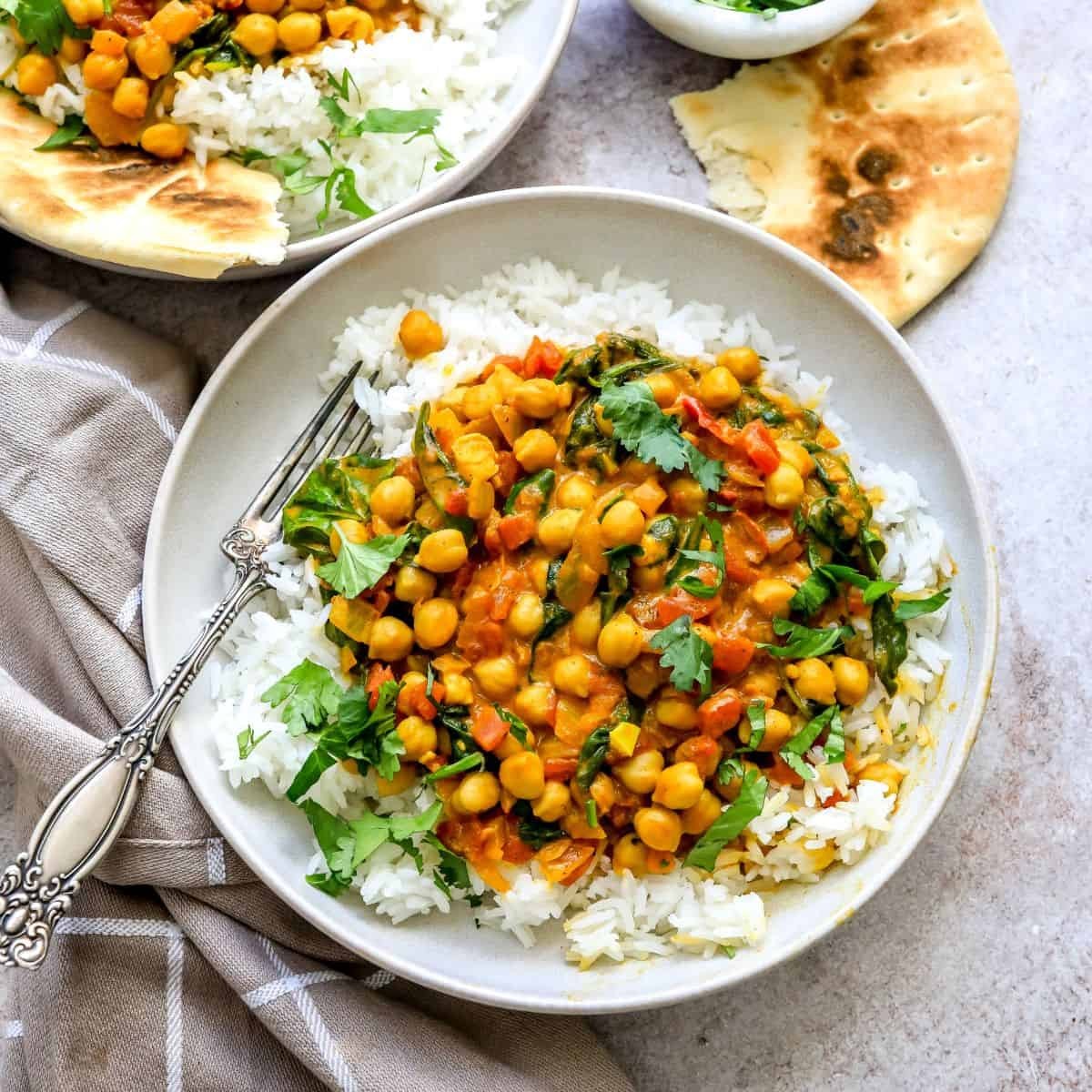 vibrant chickpea spinach curry in a rustic bowl with rice, close-up, steam rising