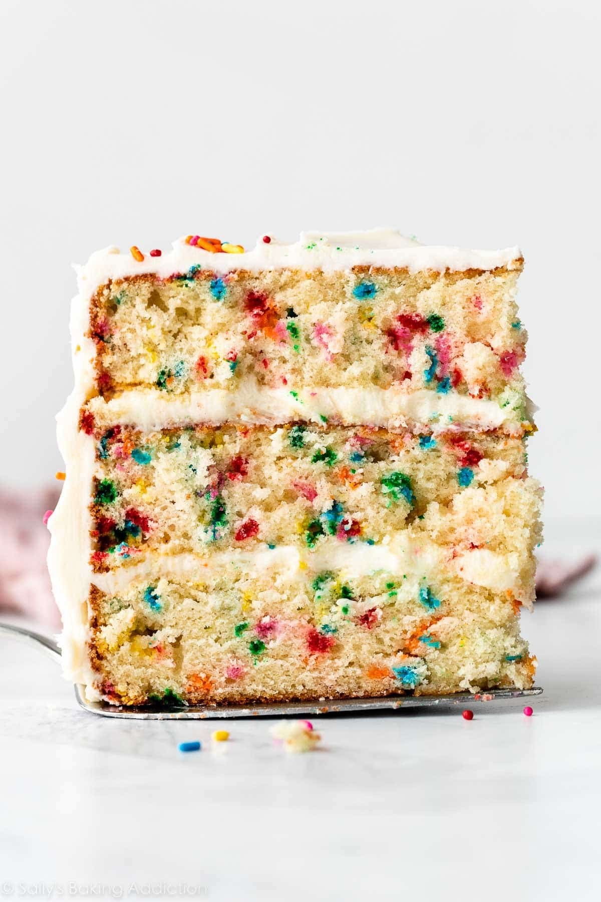 slice of confetti vanilla layer cake with sprinkles