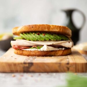 close-up of a turkey and avocado sandwich on a wooden cutting board