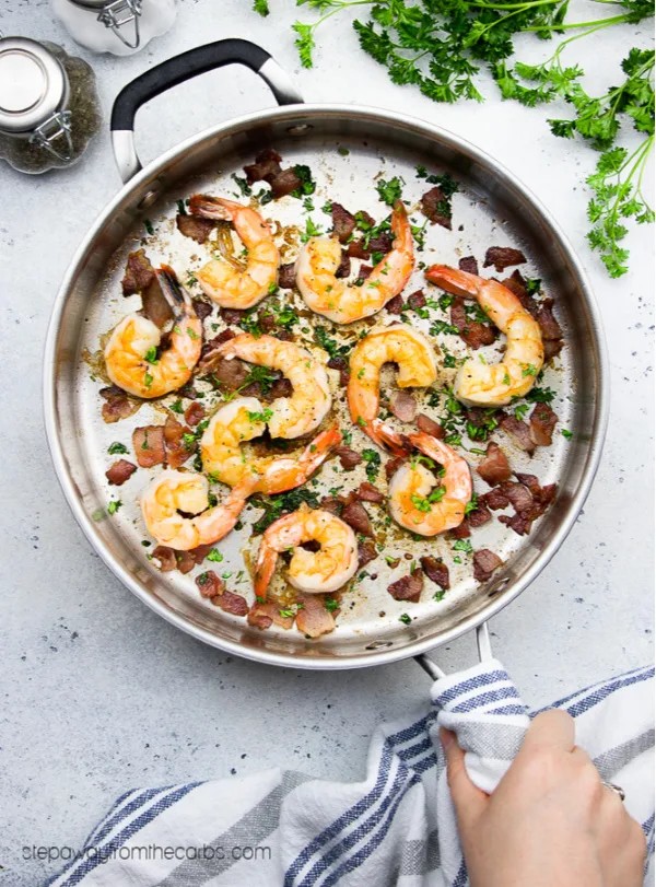 close-up of bacon garlic butter shrimp skillet, garnished with parsley