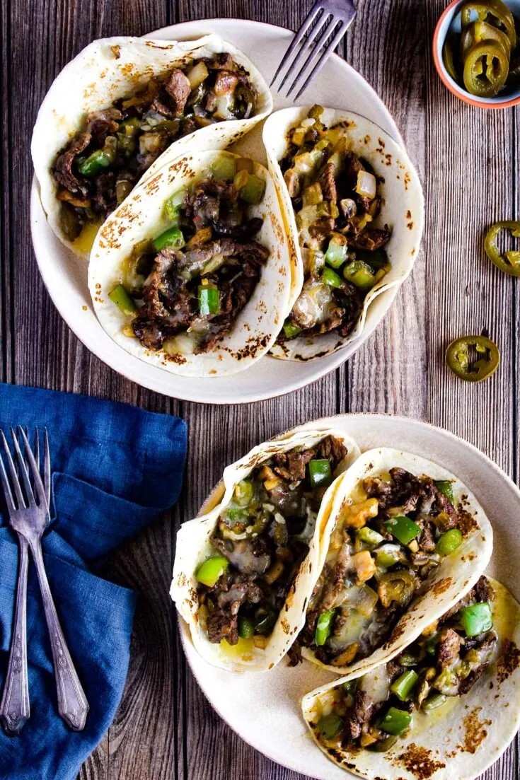 Philly cheesesteak ground beef tacos with melted provolone cheese