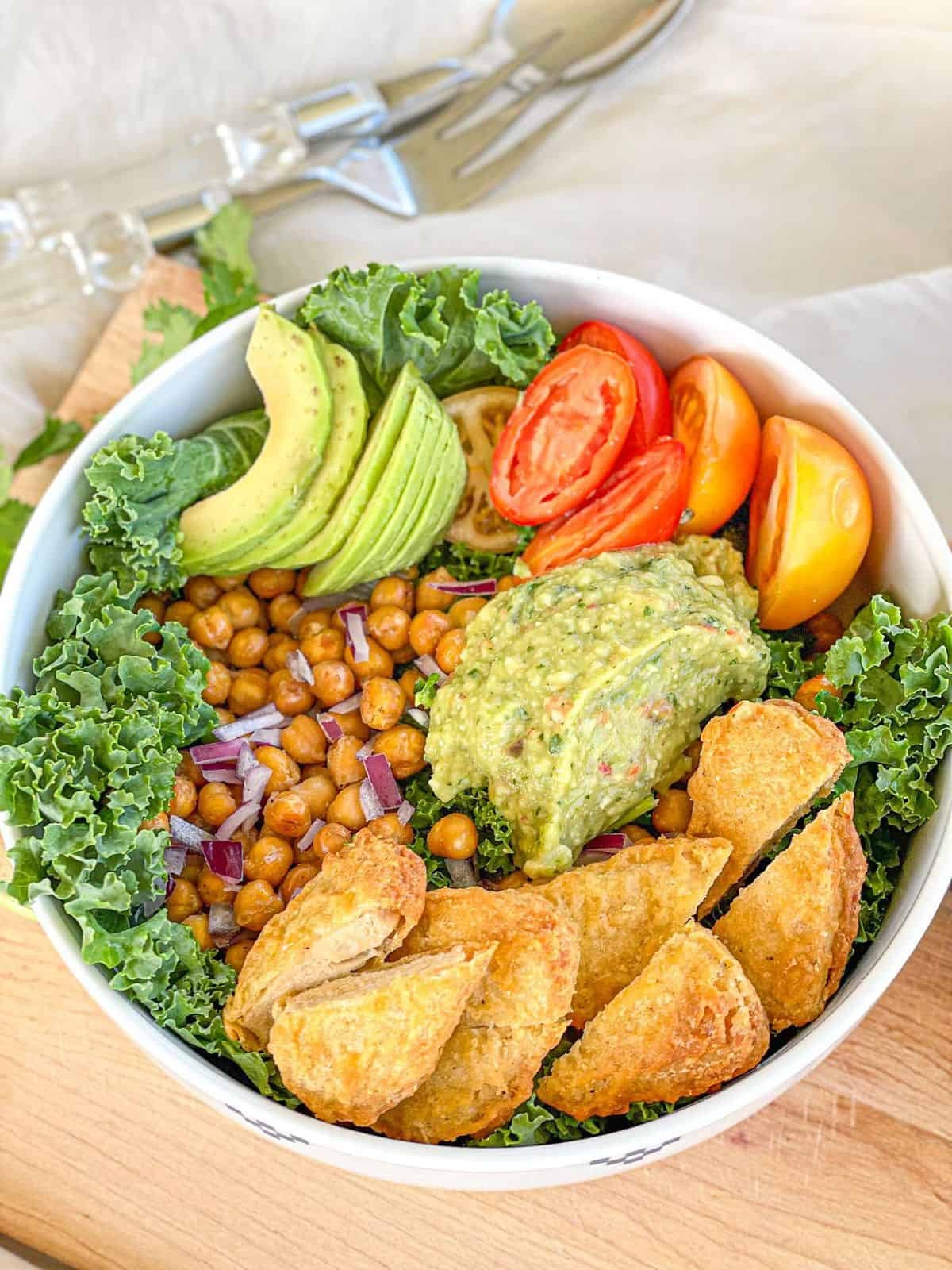 Vibrant healthy avocado dinner plate with roasted chickpeas, fresh vegetables, and a creamy dressing