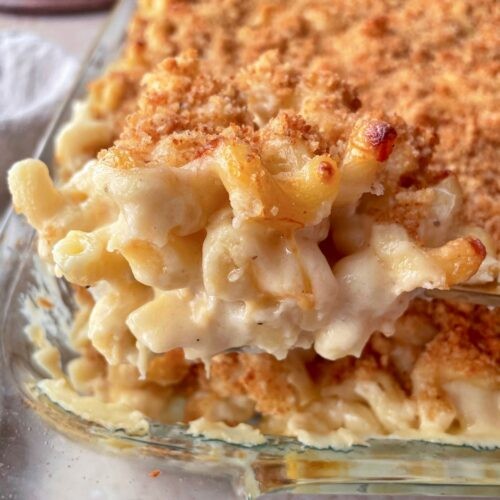 Creamy mac and cheese with a golden-brown baked topping, in a rustic bowl