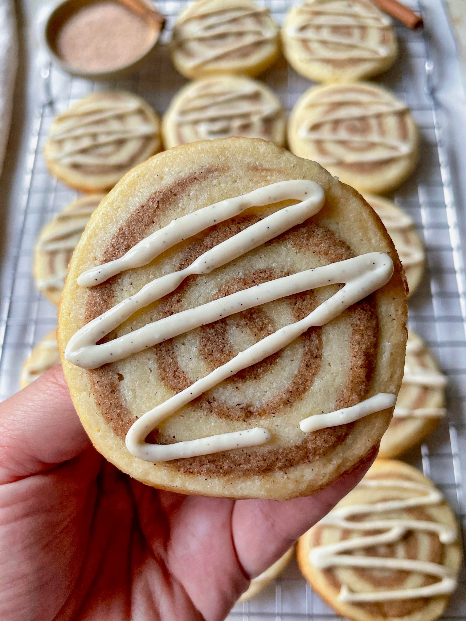 Cinnamon pinwheel cookies on a cooling rack, close-up, sugar swirl visible