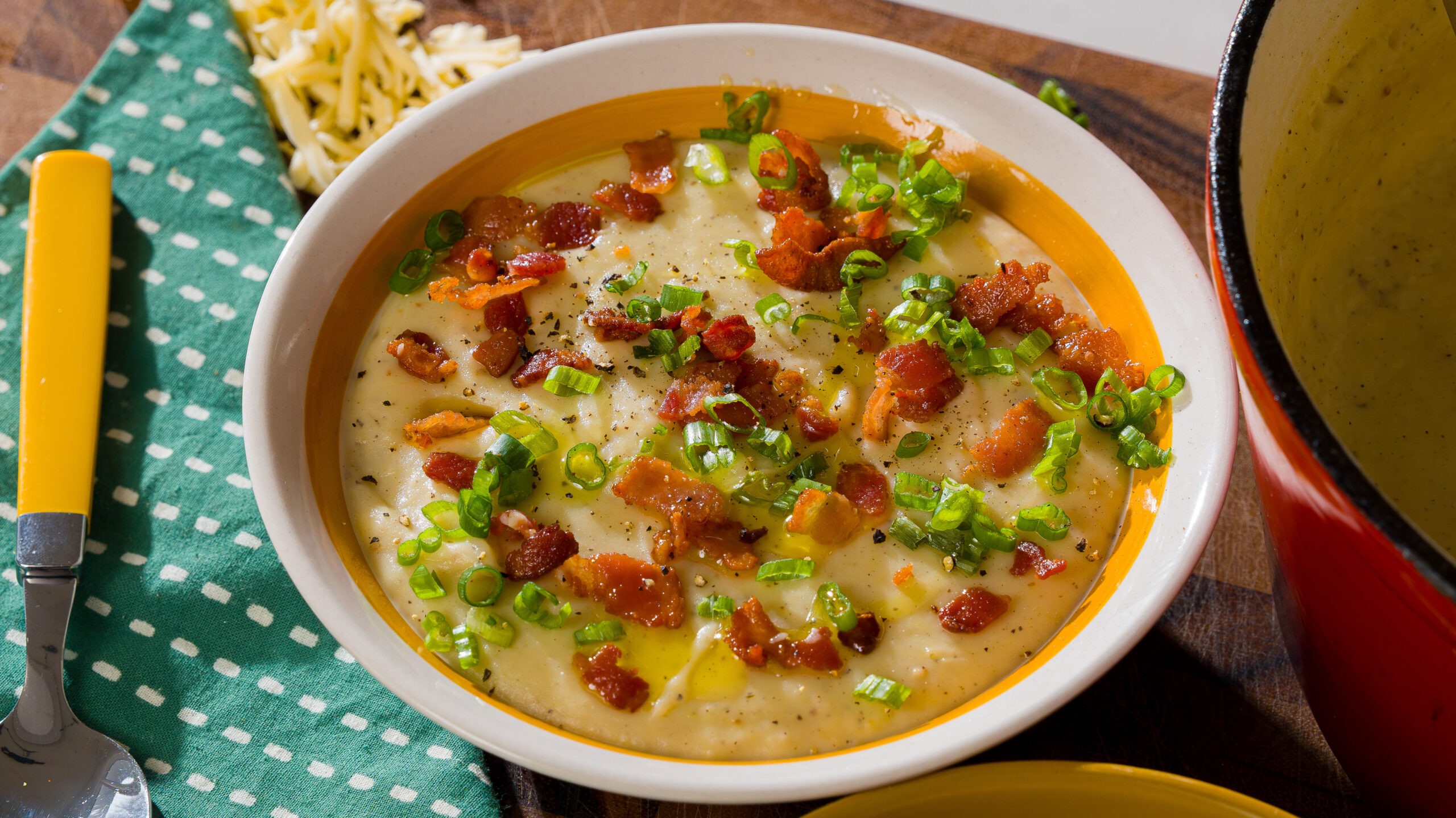 Delicious creamy potato leek soup in a bowl with crusty bread, cozy setting, comfort food
