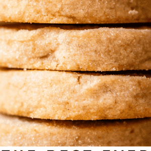 Close-up of golden shortbread cookies on a cooling rack, some with a bite taken out, rustic kitchen background