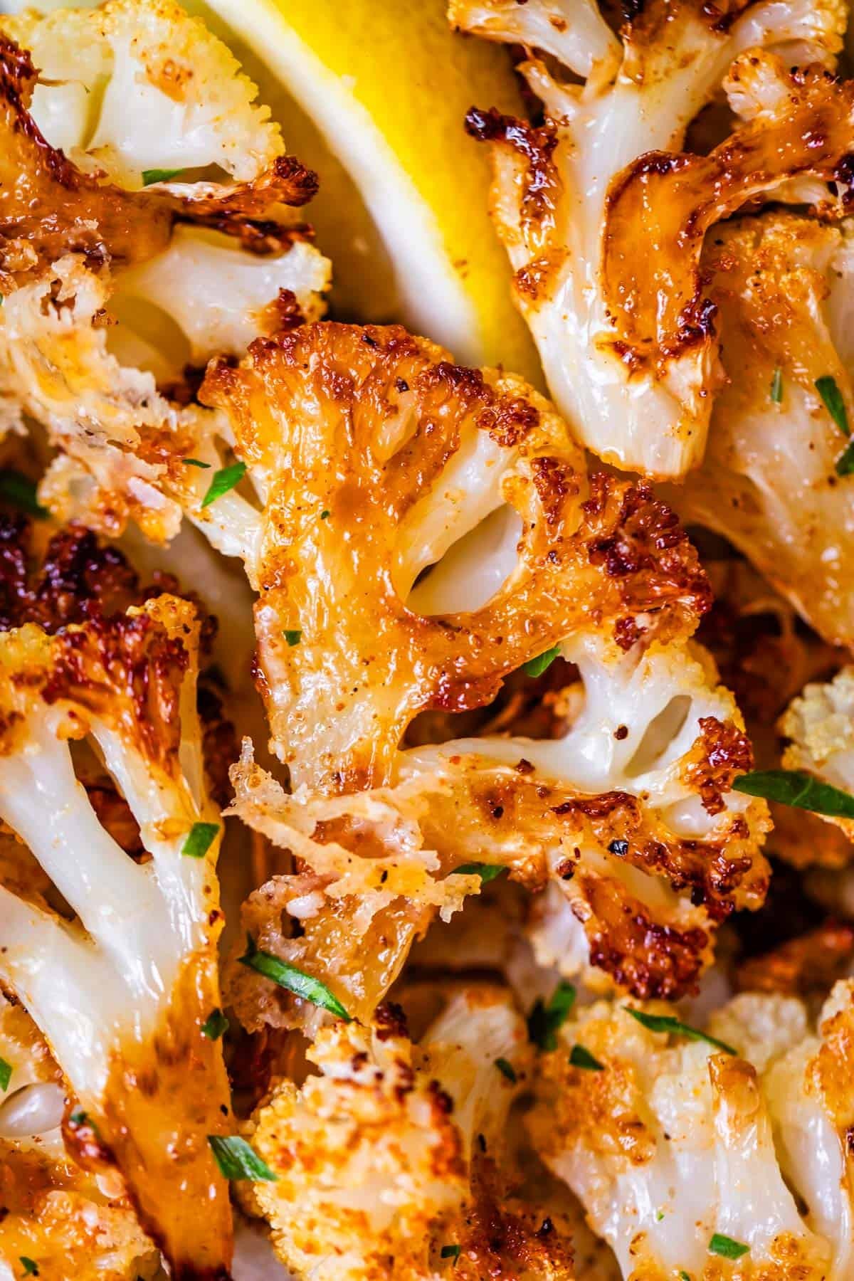 vibrant close-up of golden brown roasted cauliflower florets with visible garlic bits