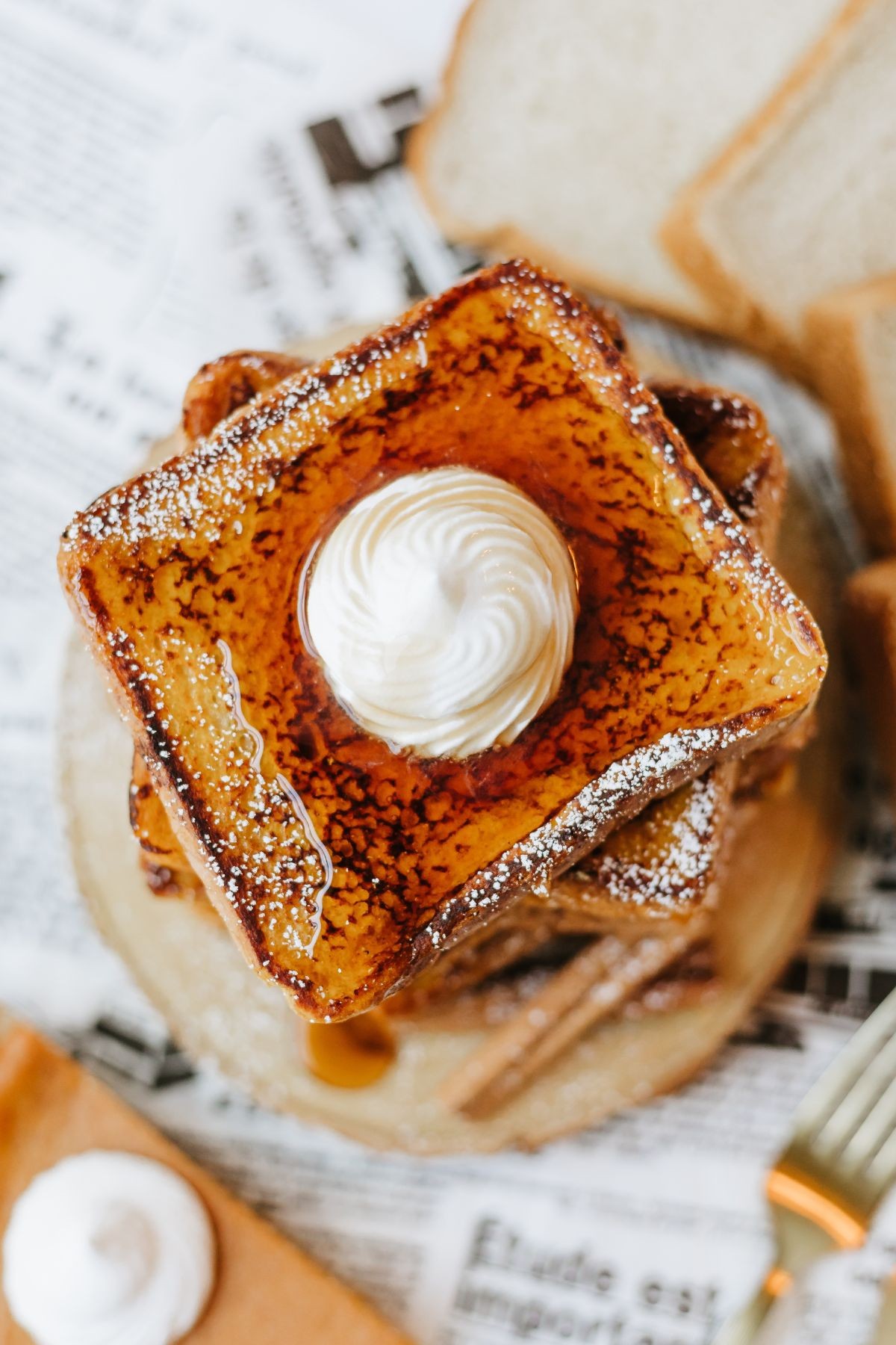 overhead shot of sliced pumpkin bread with a dusting of powdered sugar, alongside a cup of coffee