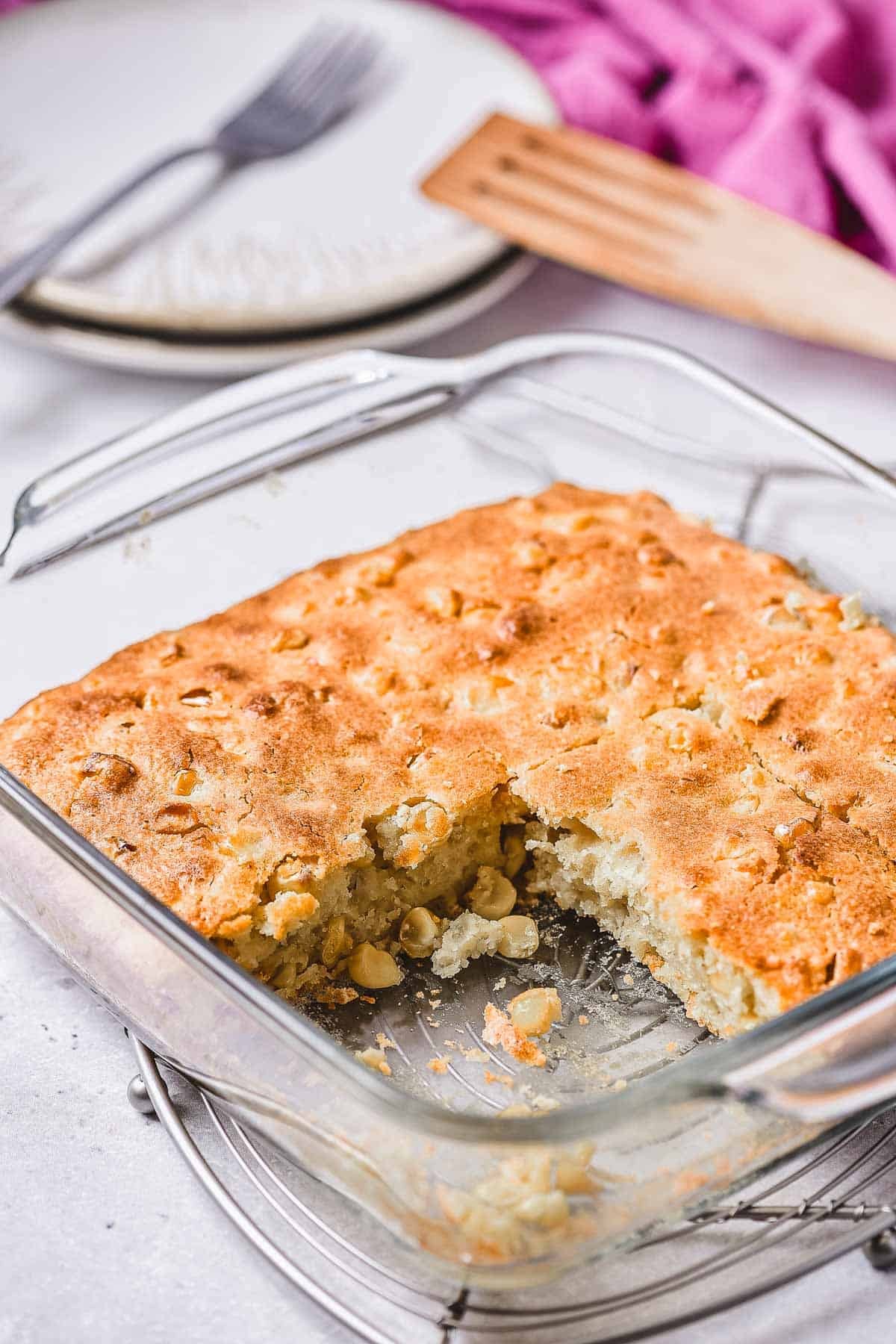 Delicious golden brown corn casserole with crispy edges, served in a rustic baking dish on a wooden table