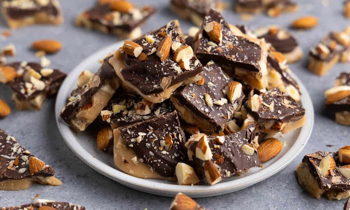 Close-up of golden almond toffee with butter crunch, scattered almonds