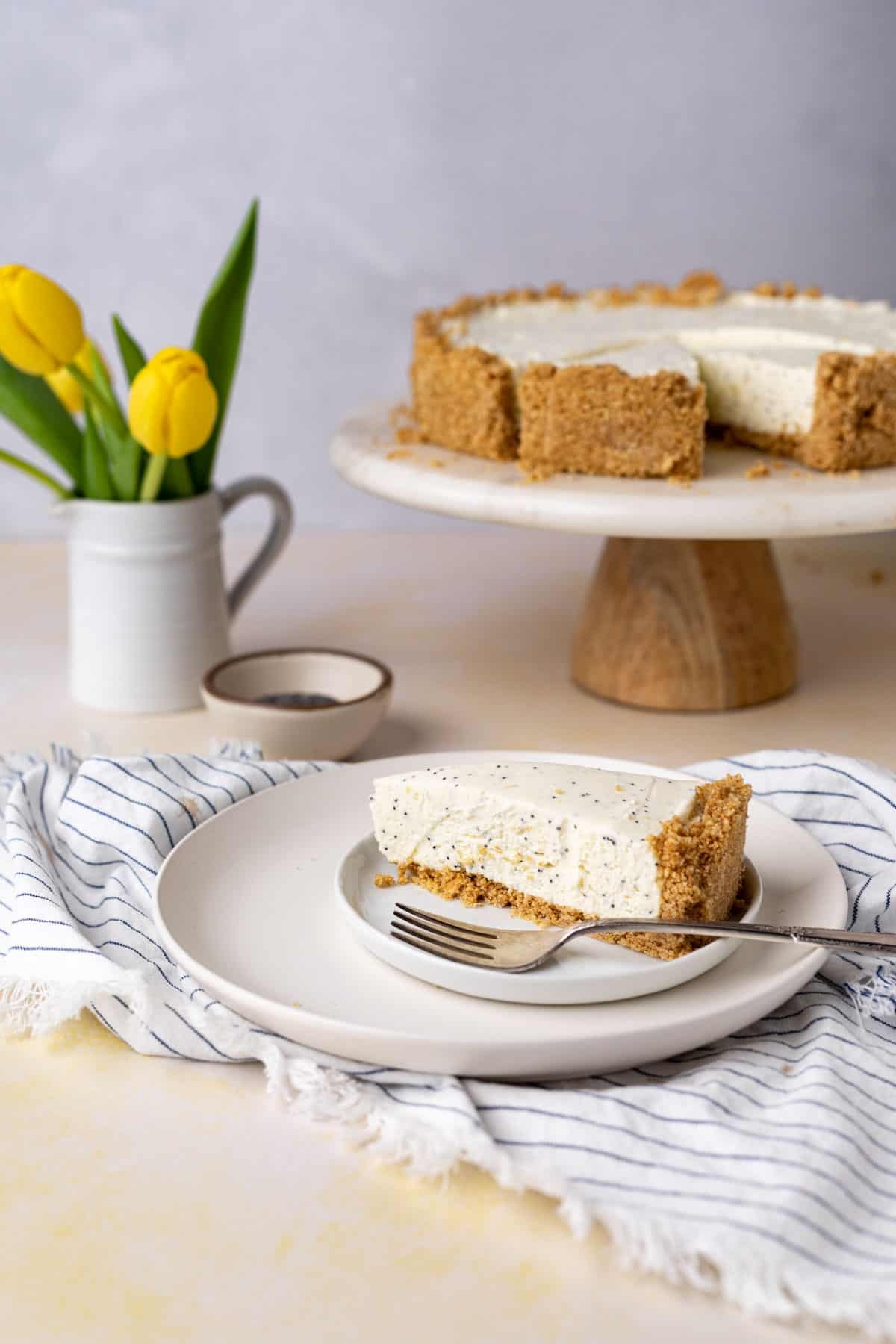 slice of lemon poppy seed strawberry cheesecake on a white plate