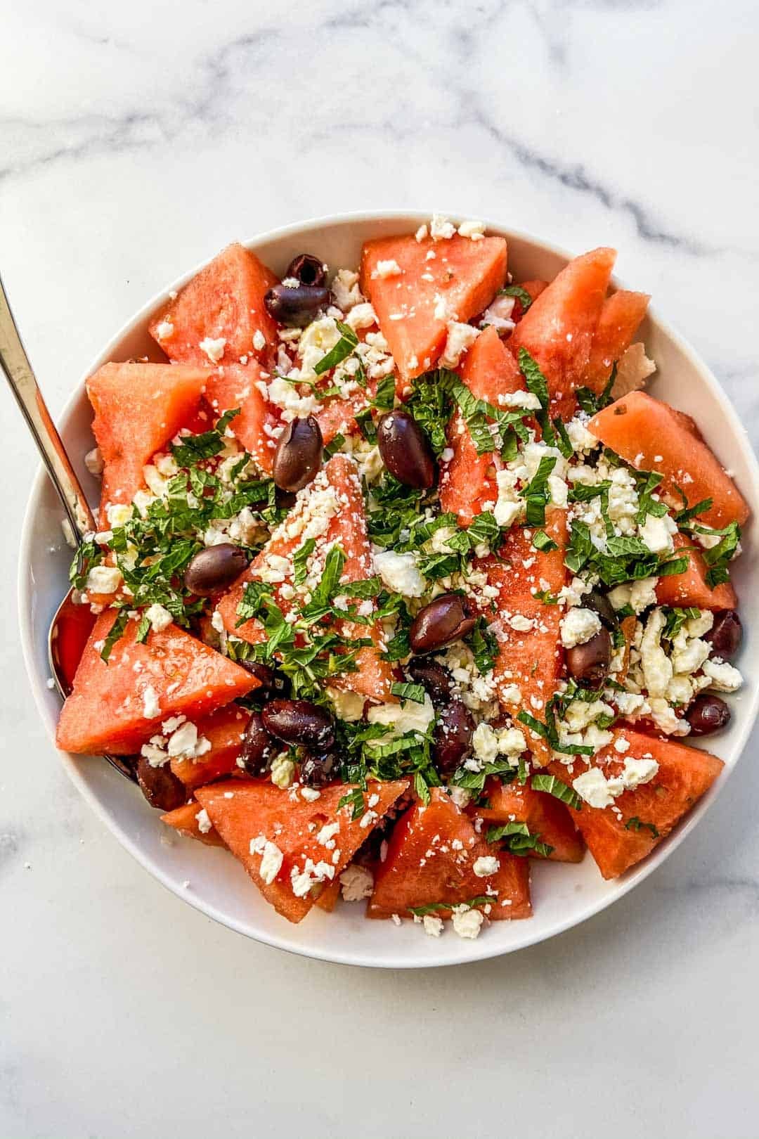 watermelon salad with kalamata olives and oregano, served outdoors