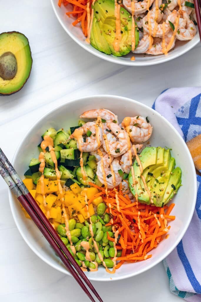 A vibrant shrimp tempura and avocado sushi bowl with colorful toppings
