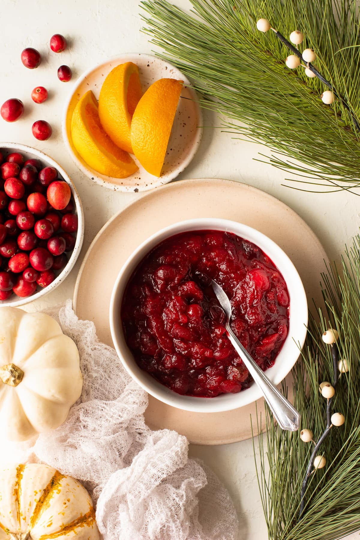Vibrant homemade cranberry sauce in a decorative bowl with fresh cranberries and orange slices