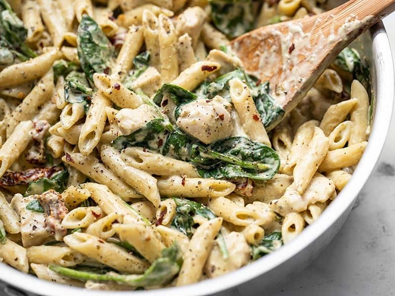 Delicious creamy pesto chicken served with pasta or rice