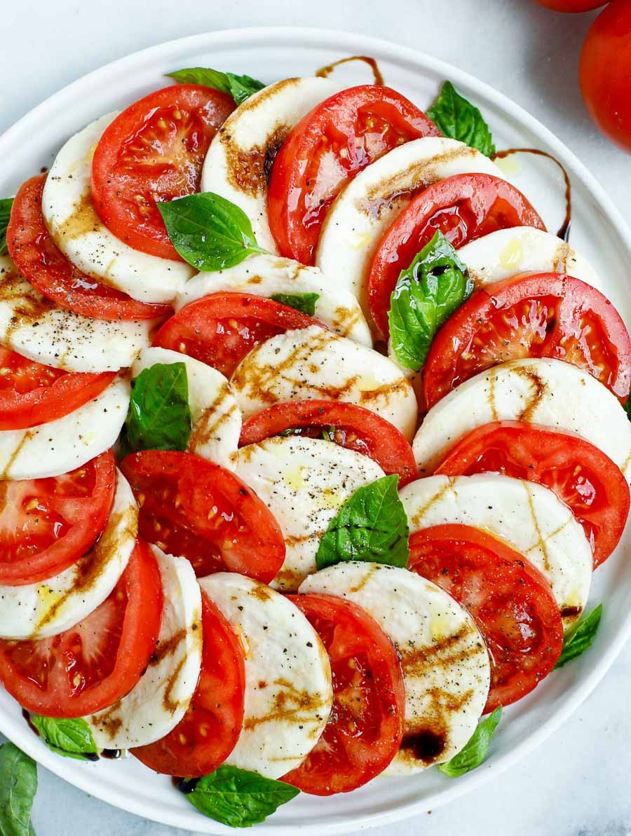 Caprese salad with fresh basil and lime wedges