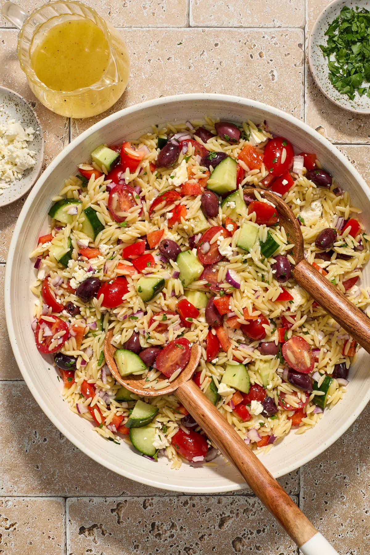 close up shot of Greek orzo pasta salad with lemon vinaigrette in a white bowl